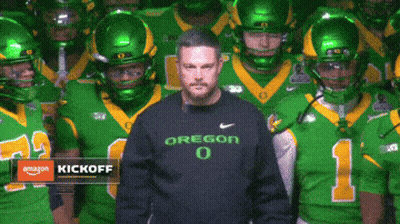 Man In Oregon Shirt In Front Of Football Team GIF
