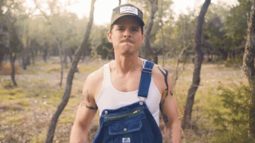 Man in Overalls and Hat With Texas Patch
