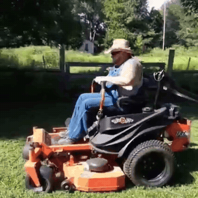 Man In Overalls Riding Lawn Mower GIF