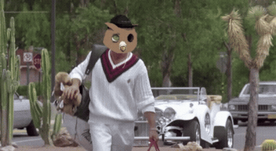 Man In Owl Mask Walking Down Street GIF