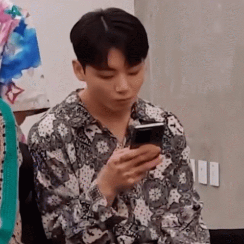 Man In Paisley Shirt Looking At Phone GIF