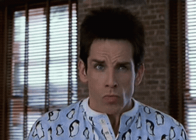 Man In Pajama Shirt With Penguins Looking At Camera GIF