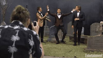 Man In Palm Tree Shirt Photographs Three Tuxedo Men At Cemetery GIF