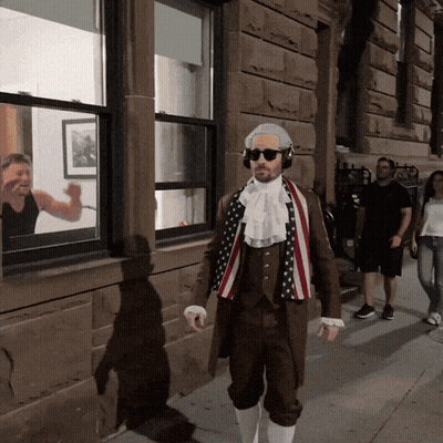 Man In Patriotic Costume Walking Down Sidewalk GIF