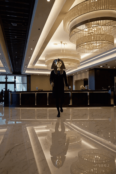Man In Pharaoh Mask Walking In Lobby GIF