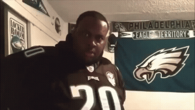 Man In Philadelphia Eagles Jersey In Front Of Banner GIF