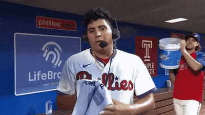 Man In Phillies Jersey In Front Of LifeBRC Sign GIF