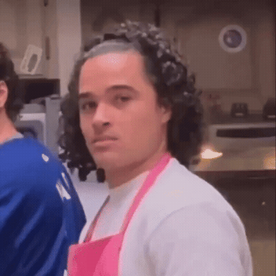 Man In Pink Apron Looking At Camera GIF