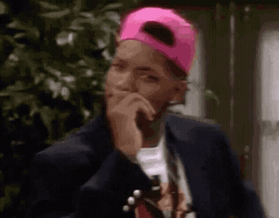 Man In Pink Baseball Cap And Suit Covering Mouth GIF