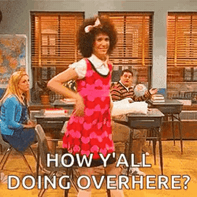 Man In Pink Dress Dancing In Classroom While Woman Sits At Desk GIF