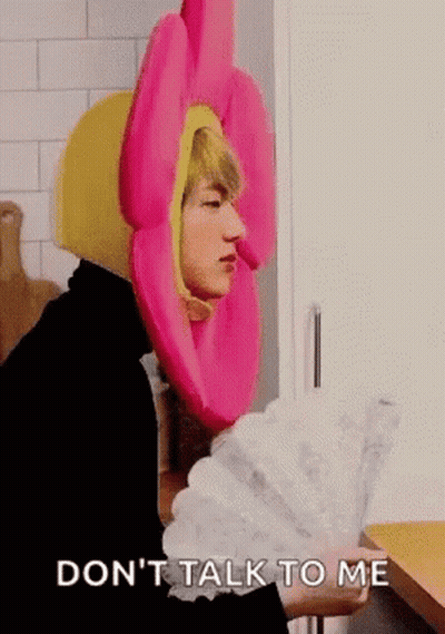 Man In Pink Flower Hat Holding Fan GIF