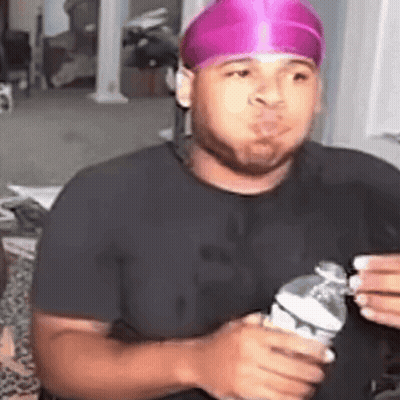 Man In Pink Headband Holding Water Making Funny Face GIF