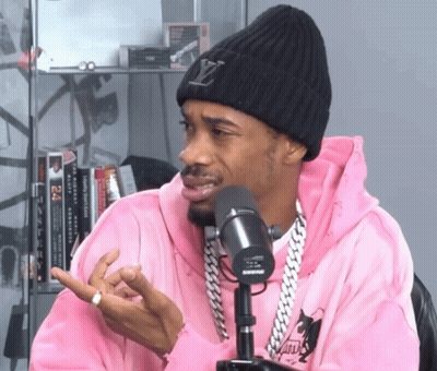 Man In Pink Hoodie And Louis Vuitton Beanie Talking Into Shure Microphone GIF