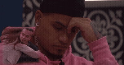 Man In Pink Hoodie Touching Forehead Hugged By Woman GIF