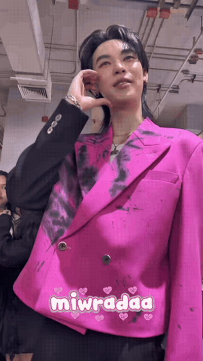 Man In Pink Jacket And Black Pants Standing With Others GIF