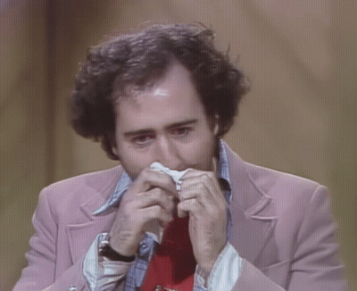 Man In Pink Jacket And Red Tie Holding Paper In Mouth GIF