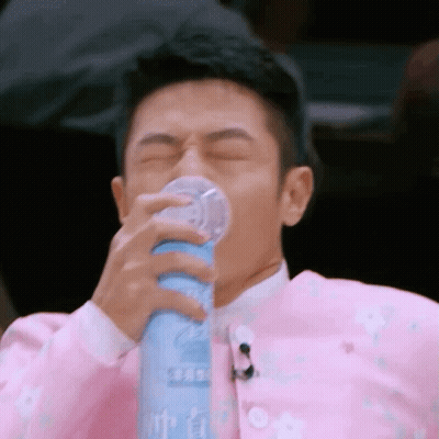 Man In Pink Jacket Drinking From Bottle GIF