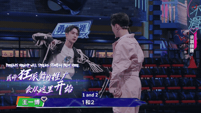 Man In Pink Jacket In Front Of Sign Saying 1 And 2 GIF