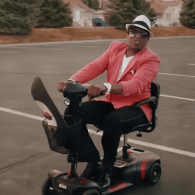 Man In Pink Jacket Riding Scooter GIF