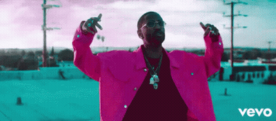 Man in Pink Jacket with Arms Outstretched on Roof