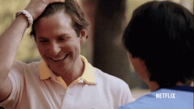 Man In Pink Polo Smiling And Touching Hair GIF