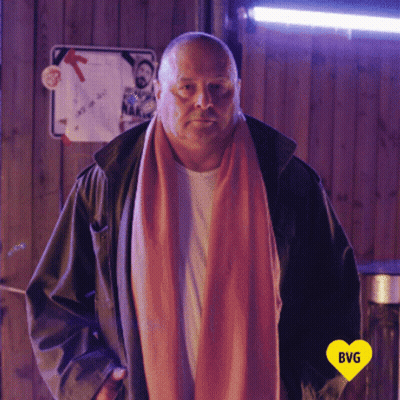 Man In Pink Scarf And Black Jacket With Yellow Heart Saying BG GIF