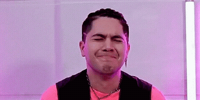 Man In Pink Shirt And Black Vest Making A Face GIF