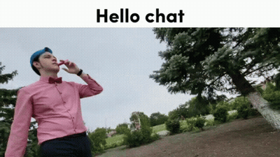 Man In Pink Shirt And Blue Hat Talking On Cell Phone In Front Of Tree GIF