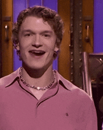 Man In Pink Shirt And Chain Smiling GIF