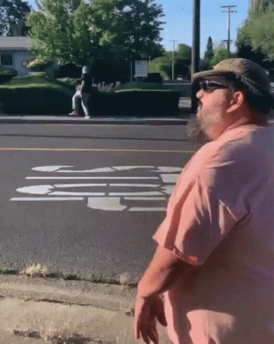 Man In Pink Shirt And Hat On Sidewalk GIF