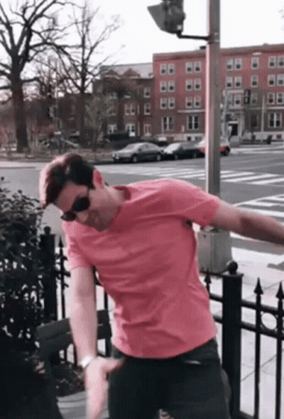 Man In Pink Shirt And Sunglasses On Street GIF