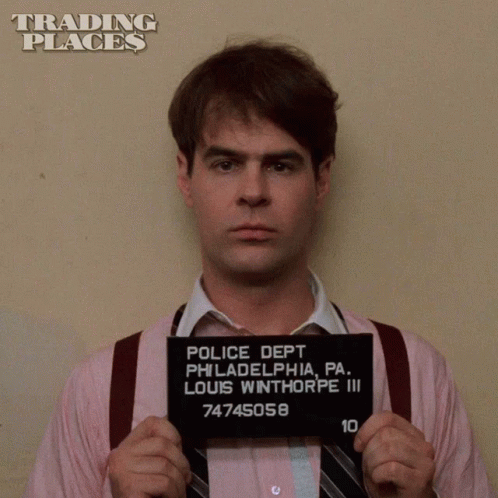 Man In Pink Shirt And Tie Holding Police Mug Shot GIF
