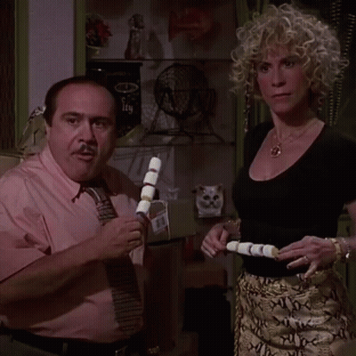 Man In Pink Shirt And Tie Next To Blonde Woman GIF