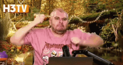 Man In Pink Shirt Holding Stick At Microphone GIF