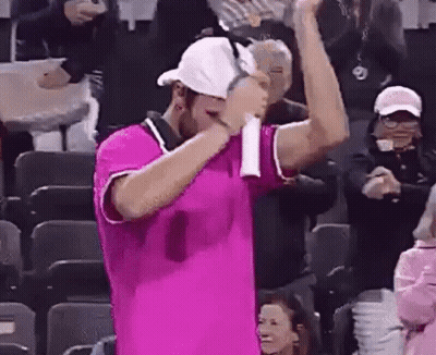 Man In Pink Shirt Holding Tennis Racquet In Front Of Crowd GIF