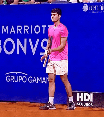 Man In Pink Shirt Holding Tennis Racquet In Front Of Marriott Bonvoy Sign GIF
