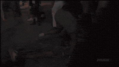 Man In Pink Shirt In Front Of Zous Wall GIF