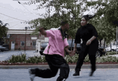 Man In Pink Shirt Running With Woman In Black Sweater GIF