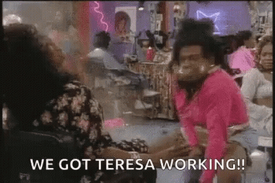 Man In Pink Shirt Sitting In Salon Talking To Woman GIF