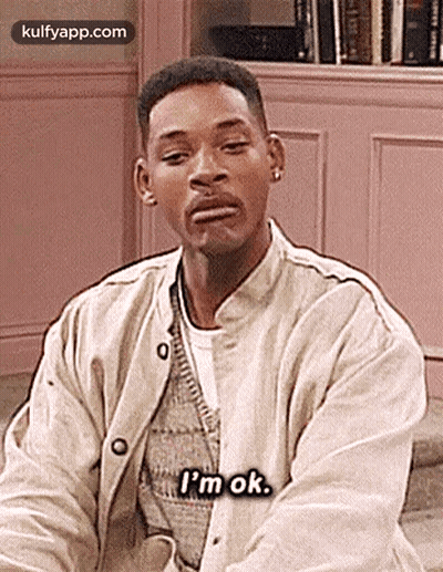 Man In Pink Shirt Sitting On Couch GIF
