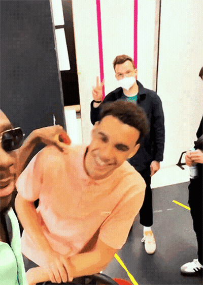 Man In Pink Shirt Smiling And Giving Peace Sign GIF