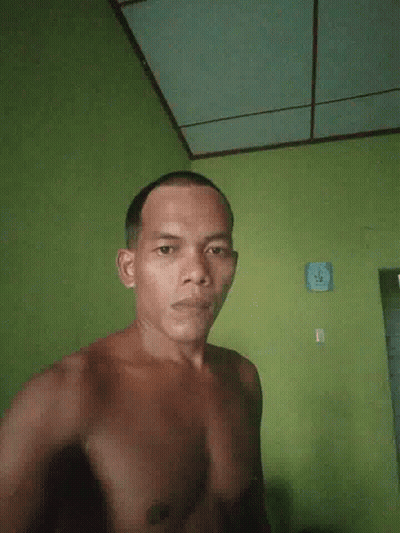 Man In Pink Shirt Standing In Front Of Pause Screen GIF