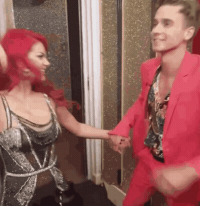 Man In Pink Suit Dancing With Red-Haired Woman GIF