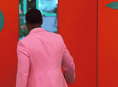 Man In Pink Suit In Front Of Red Door GIF