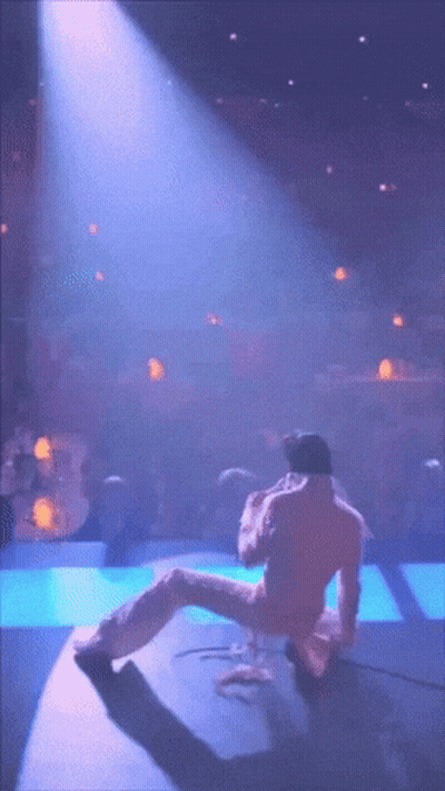 Man In Pink Suit Kneeling On Stage GIF