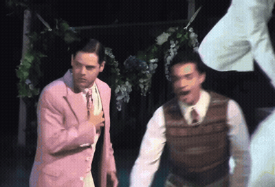 Man In Pink Suit Next To Man In Brown Vest GIF