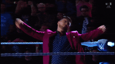 Man In Pink Suit Standing In Wrestling Ring GIF
