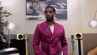 Man In Pink Suit With Guitars And Speakers And BET Logo GIF