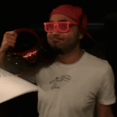 Man In Pink Sunglasses And Red Hat Holding Headphones GIF