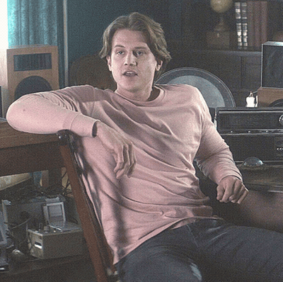 Man In Pink Sweater Sitting In Chair GIF